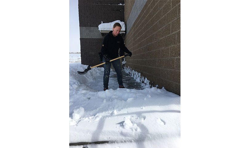 Image of Beacon Group team member shovelling snow